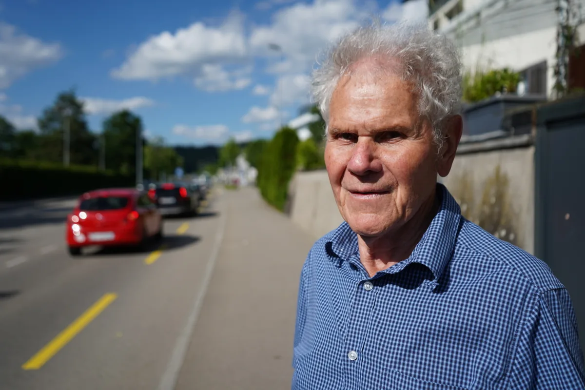 Mann steht vor einer Strasse.